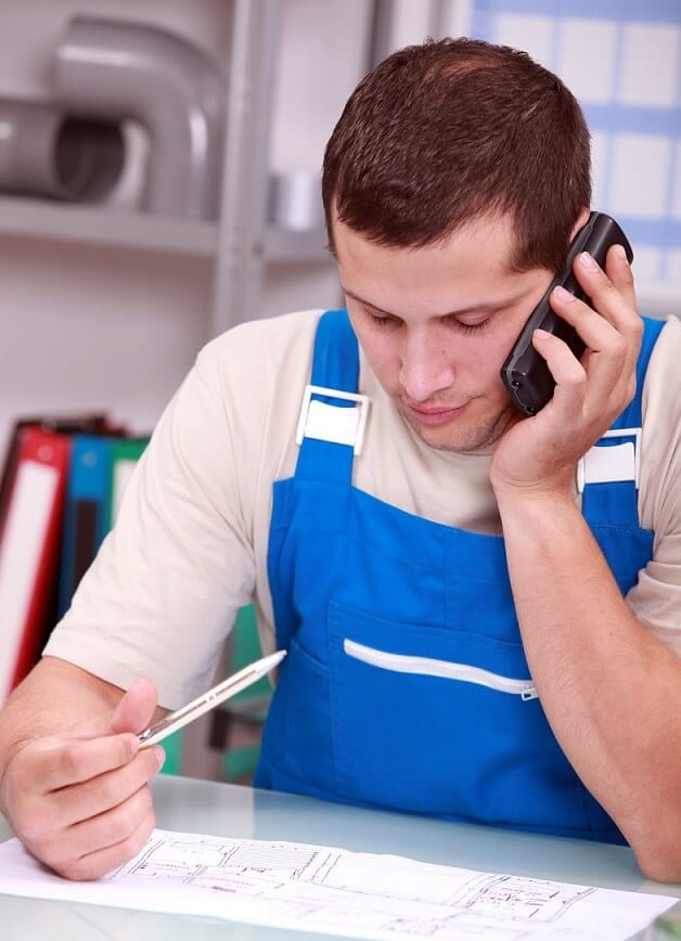 Worker on Phone Holding Pencil Studying Paper