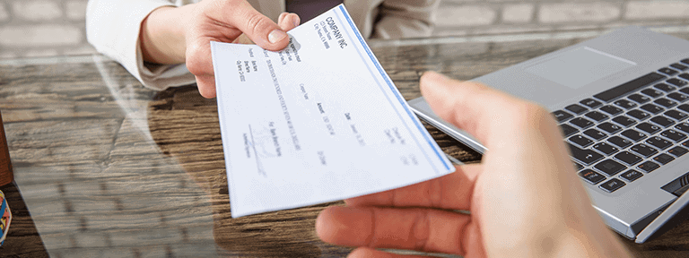 Captive Insurance Plan - Person Handing Professional Check