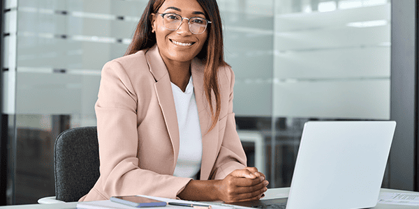 Person Smiling in Front of Laptop Providing Human Resources Compliance Guidance